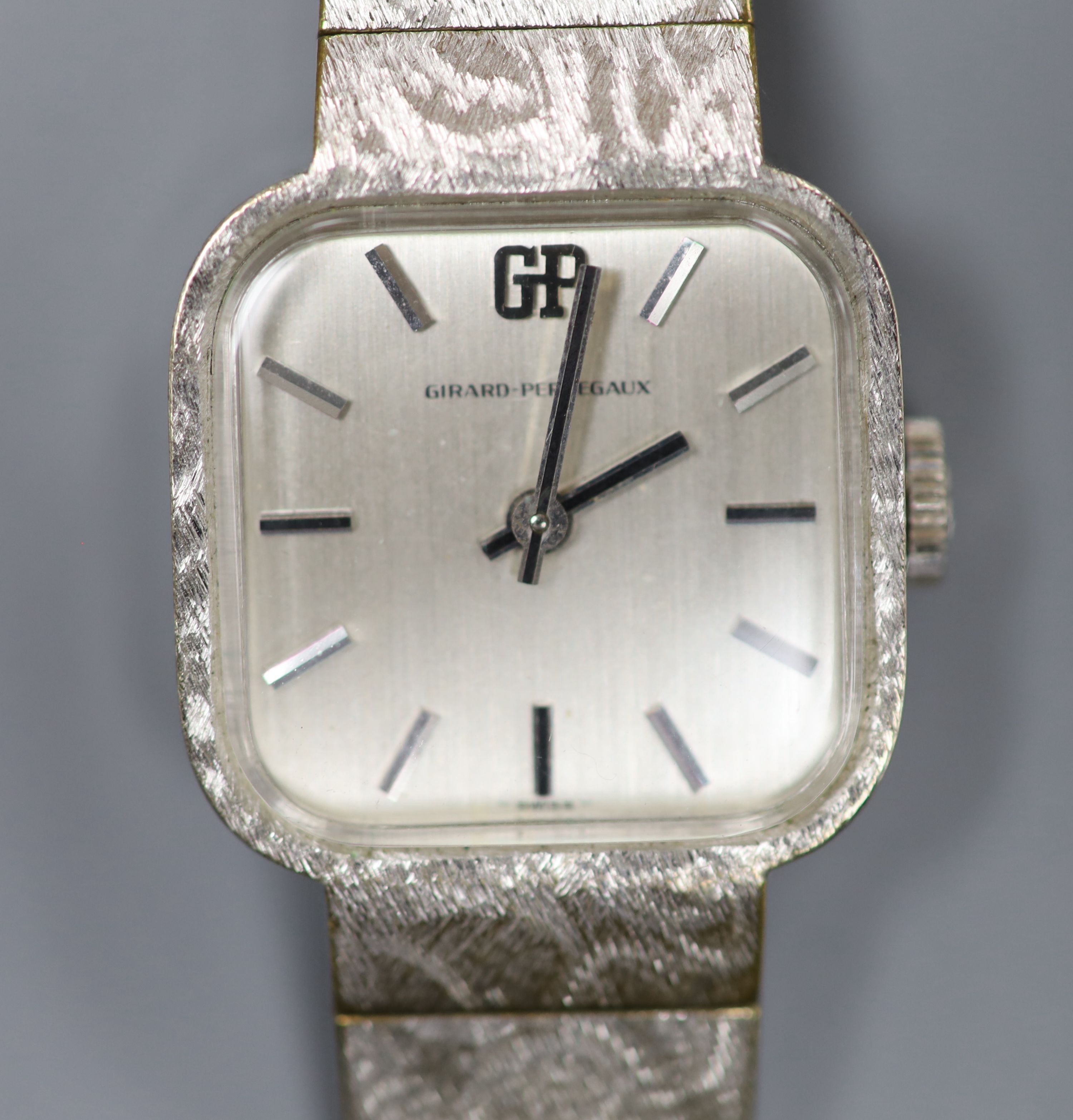 A ladys stainless steel Girard Perregaux manual wind wrist watch, on a textured white gold plated bracelet, overall 18.4cm,